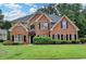 Charming brick two-story home with manicured lawn, lush greenery, and dark shutters at 1868 Birch Briar Bnd, Lawrenceville, GA 30043
