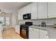 Well-lit kitchen with white cabinetry, black appliances, and ample countertop space, perfect for cooking and entertaining at 1868 Birch Briar Bnd, Lawrenceville, GA 30043