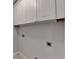 Clean laundry room features upper cabinets for storage and utility hookups at 1868 Birch Briar Bnd, Lawrenceville, GA 30043