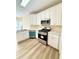 Well-lit kitchen featuring stainless steel appliances and new vinyl flooring at 4460 Greycliff Pte, Douglasville, GA 30135