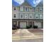 View of townhome exterior showing the multi-colored facade, garage doors, landscaping, and individual entry doors at 6361 Redan Sq, Lithonia, GA 30058