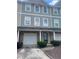 View of townhome exterior showing the multi-colored facade, garage doors, landscaping, and individual entry doors at 6361 Redan Sq, Lithonia, GA 30058