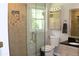 This updated bathroom features a tiled shower with glass door, plus a vanity and toilet next to a bright window at 1310 Larkview Sw Dr, Lilburn, GA 30047