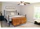 Cozy bedroom with ceiling fan, wooden dresser, plush carpet, and lots of natural light from the large window at 1310 Larkview Sw Dr, Lilburn, GA 30047