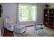 Bright, neutral-toned bedroom with large windows, hardwood flooring, and comfortable seating area at 1310 Larkview Sw Dr, Lilburn, GA 30047