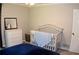 This calming Bedroom includes a white crib and dresser with a navy blue blanket, lit by soft overhead light at 1310 Larkview Sw Dr, Lilburn, GA 30047