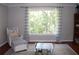 Bright, neutral-toned bedroom with large windows, hardwood flooring, and comfortable seating area at 1310 Larkview Sw Dr, Lilburn, GA 30047