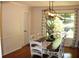 Dining room with wood floors, long table, white chairs, and modern light fixture at 1310 Larkview Sw Dr, Lilburn, GA 30047