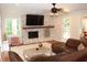 A cozy living room features a brick fireplace, hardwood floors, and a comfortable leather couch at 1310 Larkview Sw Dr, Lilburn, GA 30047