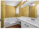 This bathroom has a white vanity and bathtub with wood-look floors, and yellow walls at 305 Hickory Pointe Ct, Villa Rica, GA 30180