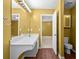 Bathroom with double vanity, wood-look floors, toilet, and doorway to a carpeted bedroom at 305 Hickory Pointe Ct, Villa Rica, GA 30180