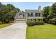Charming two-story home featuring a well-manicured lawn, two-car garage, and traditional architectural details at 305 Hickory Pointe Ct, Villa Rica, GA 30180