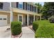 Close-up of the home's inviting front porch with columns, a cozy swing, and manicured bushes at 305 Hickory Pointe Ct, Villa Rica, GA 30180