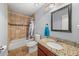 Full bathroom with tiled shower, vanity with granite countertops, and updated fixtures at 5016 Comanche Nw Ct, Lilburn, GA 30047