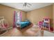 Bright bedroom with a ceiling fan, play area, and large window for natural light at 5016 Comanche Nw Ct, Lilburn, GA 30047