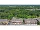Aerial view of townhomes surrounded by lush greenery with a highway in the distance at 531 Headwind Way, Alpharetta, GA 30005