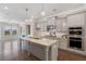 Open-concept kitchen with gray cabinets, stainless steel appliances, granite countertops, and hardwood floors at 531 Headwind Way, Alpharetta, GA 30005