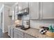 Kitchen featuring gray cabinets and granite countertops along with stainless steel oven and microwave at 531 Headwind Way, Alpharetta, GA 30005