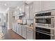 Kitchen featuring stainless steel oven and microwave along with gray cabinets and granite countertops at 531 Headwind Way, Alpharetta, GA 30005