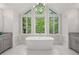 Modern bathroom features a standalone tub, vaulted ceiling, and large windows at 145 Mount Shasta Ln, Johns Creek, GA 30022