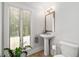 Cozy bathroom featuring pedestal sink, neutral paint, hardwood floors, and a window with lots of light at 145 Mount Shasta Ln, Johns Creek, GA 30022