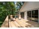 Wooden deck with outdoor seating, views of lush landscaping, and glass doors at 145 Mount Shasta Ln, Johns Creek, GA 30022