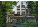 Back exterior of the home featuring multiple decks and lush, green surroundings at 145 Mount Shasta Ln, Johns Creek, GA 30022
