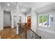Hallway featuring hardwood floors, window views, and a staircase at 145 Mount Shasta Ln, Johns Creek, GA 30022