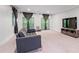 Spacious living room features a comfortable sofa, media center, and plenty of natural light from double doors at 145 Mount Shasta Ln, Johns Creek, GA 30022