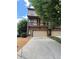 Attractive townhome showcasing a cozy balcony, stone accents, and ample parking on a sunny day at 3235 Chutney Ct, Avondale Estates, GA 30002
