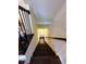 Elegant staircase with dark wood steps, white walls, and a view towards a sunlit door at 3235 Chutney Ct, Avondale Estates, GA 30002
