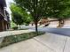 Street view of townhomes, featuring attached garages and mature trees, on a well-maintained street at 3235 Chutney Ct, Avondale Estates, GA 30002