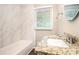 Bathroom featuring granite countertop, decorative mirror, and white tile backsplash at 4009 Kirksford Dr, Decatur, GA 30035