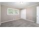 Comfortable bedroom featuring carpet floors, neutral paint, and a window overlooking the yard at 4009 Kirksford Dr, Decatur, GA 30035