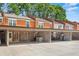 A well maintained exterior showing carports for a group of brick townhomes at 4113 Ashford Green Dr, Duluth, GA 30096
