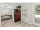 Hallway leading to a dining room with a dark wood cabinet and wood look tile flooring at 4113 Ashford Green Dr, Duluth, GA 30096