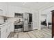 Modern kitchen with stainless steel appliances, white cabinets, and wood-look tile flooring at 4113 Ashford Green Dr, Duluth, GA 30096