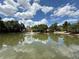 A calm pond reflects sky and trees, with a fountain enhancing the community's serene atmosphere at 4113 Ashford Green Dr, Duluth, GA 30096