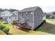 A house with a deck over a red brick landing in a grassy backyard with a dark mulch bed at 4250 Pembia Dr, Cumming, GA 30028