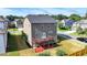 Backyard view shows house with a deck over a red brick landing and a grassy lawn and wooded neighborhood at 4250 Pembia Dr, Cumming, GA 30028