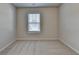 This bedroom has neutral walls and carpet and a window for natural light at 4250 Pembia Dr, Cumming, GA 30028