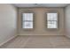 This bedroom features carpet, neutral walls, and two windows for natural light at 4250 Pembia Dr, Cumming, GA 30028