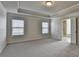 A spacious bedroom with a tray ceiling and two windows allowing for natural light at 4250 Pembia Dr, Cumming, GA 30028