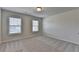 This bedroom has two windows for ample natural light, neutral walls and carpet at 4250 Pembia Dr, Cumming, GA 30028