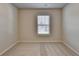 This bedroom has neutral walls and carpet and a window for natural light at 4250 Pembia Dr, Cumming, GA 30028