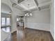 Dining room features coffered ceilings, pendant lighting, hardwood floors, and transitions into the kitchen area and outdoor access at 4250 Pembia Dr, Cumming, GA 30028