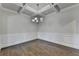 An empty dining room with hardwood floors, wainscoting, trey ceilings and a decorative chandelier at 4250 Pembia Dr, Cumming, GA 30028