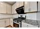 Close-up of KitchenAid stainless steel oven and stove top with white tile backsplash and granite countertop at 4250 Pembia Dr, Cumming, GA 30028
