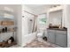 Cozy bathroom featuring a shower-tub combo, decorative floor tiles, and ample shelf storage at 853 Gaston Sw St, Atlanta, GA 30310