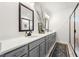 Elegant bathroom featuring double sink vanity with gray cabinets, quartz countertop, and decorative mirrors and rug at 853 Gaston Sw St, Atlanta, GA 30310